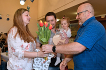 Místostarosta obce předává rodičům tulipány